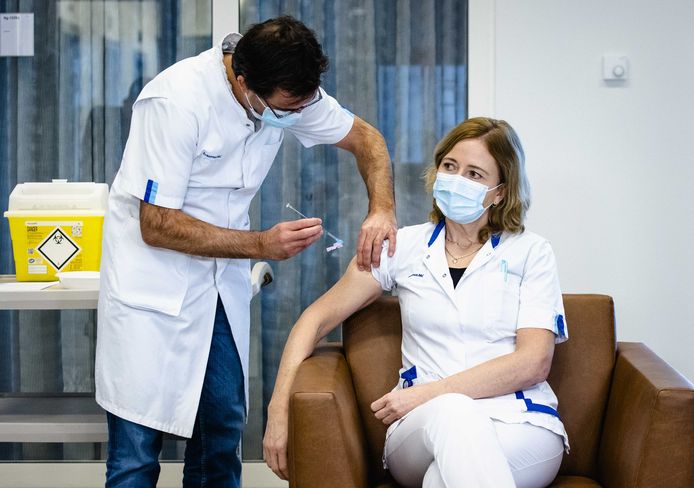 Een verpleegkundige laat zich vaccineren.