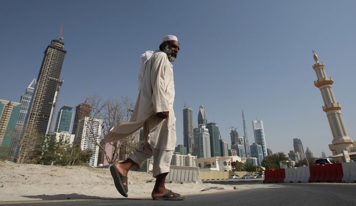 Een man met de  Sheikh Zayed Road in Dubai op de achtergrond.