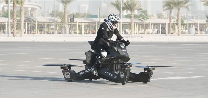 Een politieman in Dubai probeert een hoverbike te laten opstijgen.