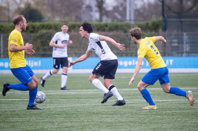 Lunteren-aanvaller Max Degenaar (midden) aan de bal tegen VRC.