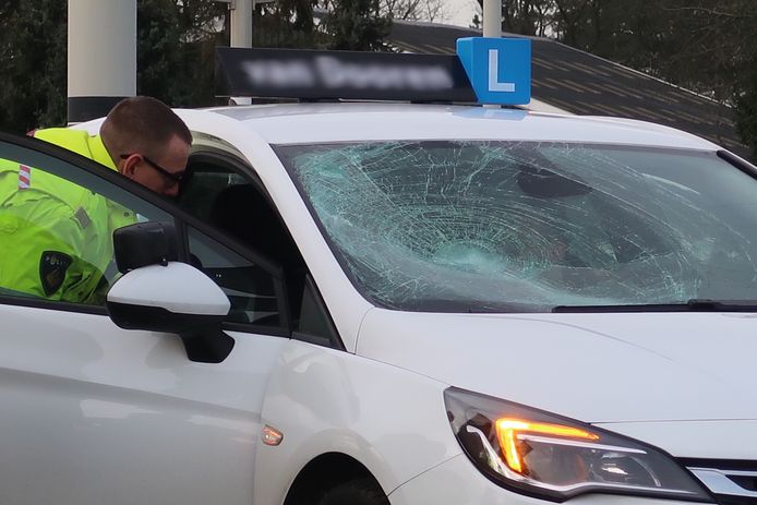 De fietser kwam in botsing met een lesauto.