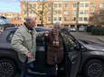 Chauffeur Bennie Temmink helpt mevrouw Kuiper uit de auto.