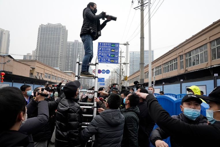Fotografen en journalisten proberen een glimp op te vangen van Marion Koopmans en de andere leden van de WHO-missie bij hun bezoek aan de Huanan Seafood Market in Wuhan, die in verband wordt gebracht met de uitbraak van het coronavirus.  Beeld AP