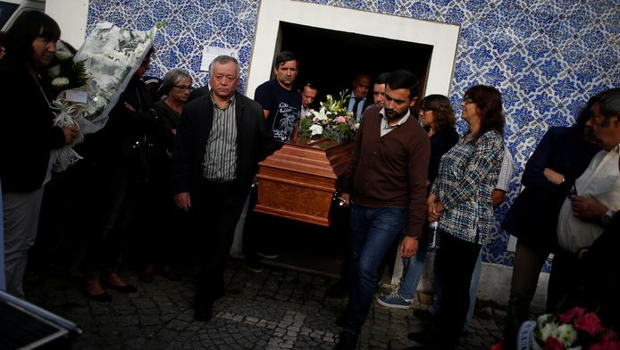 Familieleden dragen de kist van een van de dodelijke slachtoffers van de bosbrand in Vila Nova naar buiten.