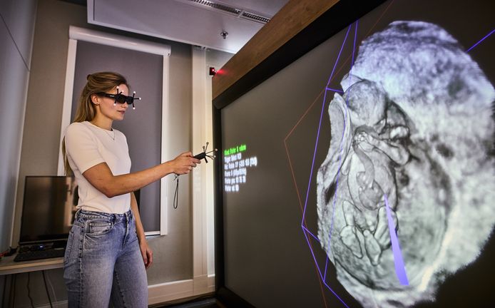 Arts-onderzoeker Naomi Graafland van het Erasmus MC in actie bij het grote scherm, waarop een hologram van een foetus rondzweeft.