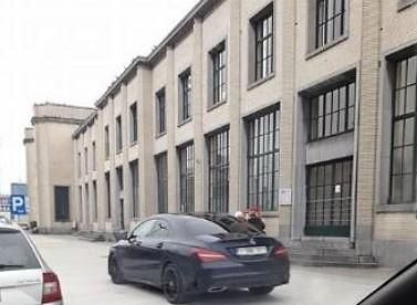 Een automobilist rijdt over het voetpad aan het station.