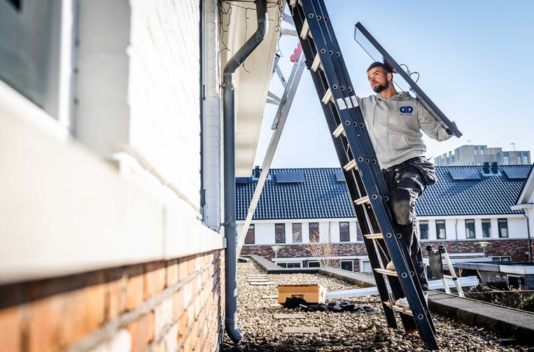 Zonnepanelen worden op het dak van een woning in Vlaardingen geïnstalleerd.  Beeld ANP