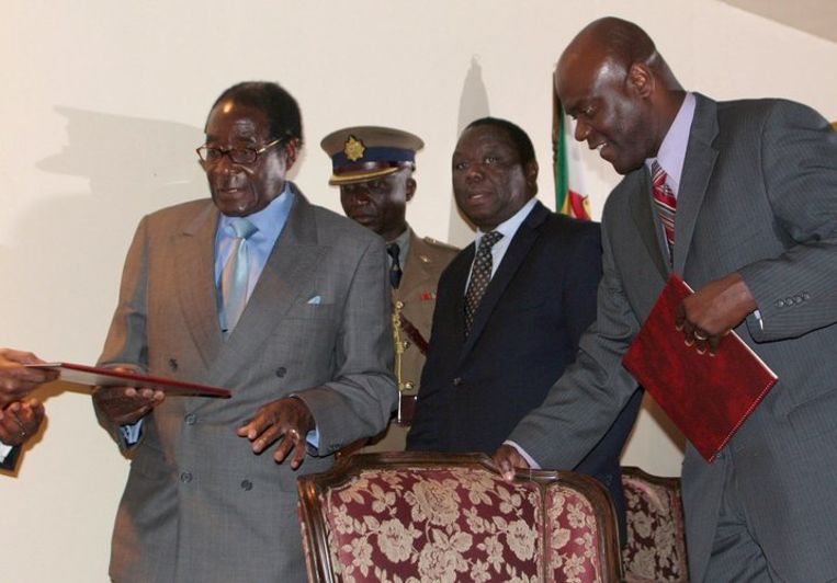 Mugabe (l.) en Tsvangirai (m.) tijdens de ondertekening. Foto EPA Beeld 