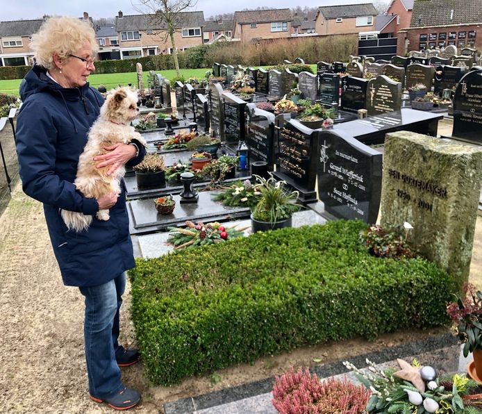 Gé Gortemaker-Keizer met haar hondje Guusje bij het graf van haar man.