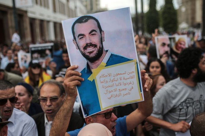Betogers dragen een portret van Nasser Zefzafi tijdens een protestmars in Rabat, vandaag, tegen de zware celstraffen die de Riffijnse protestleider en ruim 50 voormannen gisteren opgelegd kregen.