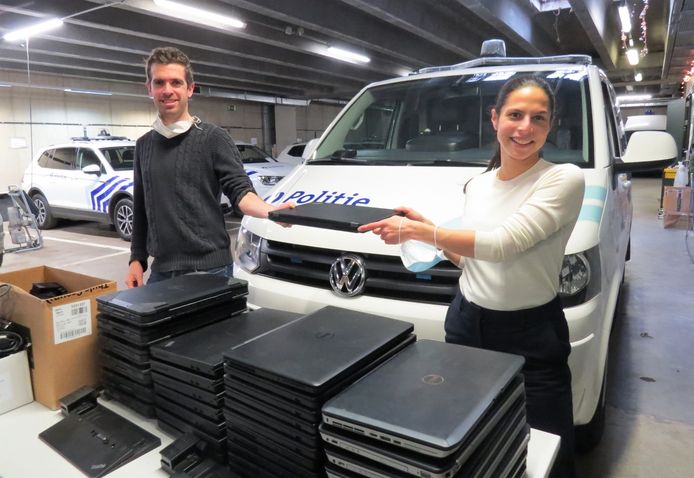 De politie van Leuven overhandigt 32 laptops aan schepen Lalynn Wadera.