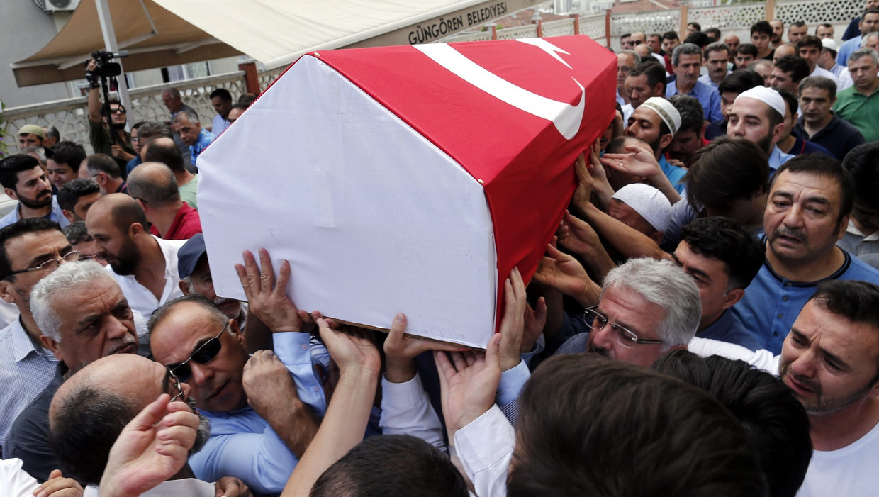 Nabestaanden van Siddik Turgan, een douanier die om het leven kwam bij de aanslag op luchthaven Atatürk, dragen zijn kist tijdens de begrafenis. Beeld epa
