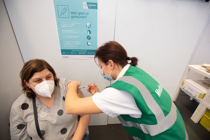 Een zorgmedewerker krijgt een prik in het vaccinatiecentrum van Bilzen, 23 februari.