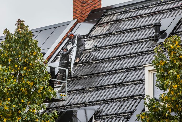 Monteurs verwijderen de zonnepanelen van daken in de De Booijstraat in Delft. Ze kijken ze na omdat er eerder op het dak van een huis in de nabijgelegen Wissingstraat twee keer spontaan brand ontstond.