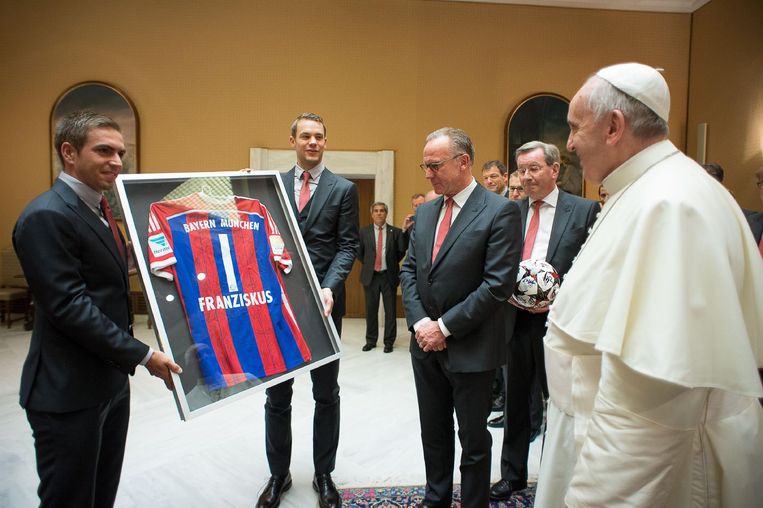 De paus ontvangt een cadeau van Bayern München in de vorm van een eigen T-shirt met handtekeningen van de spelers. Beeld afp
