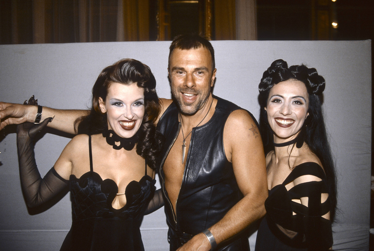 Thierry Mugler tijdens een benefiet in 1993 in Wenen samen met twee gasten, ze dragen alle drie outfits door hem ontworpen Beeld BELGAIMAGE