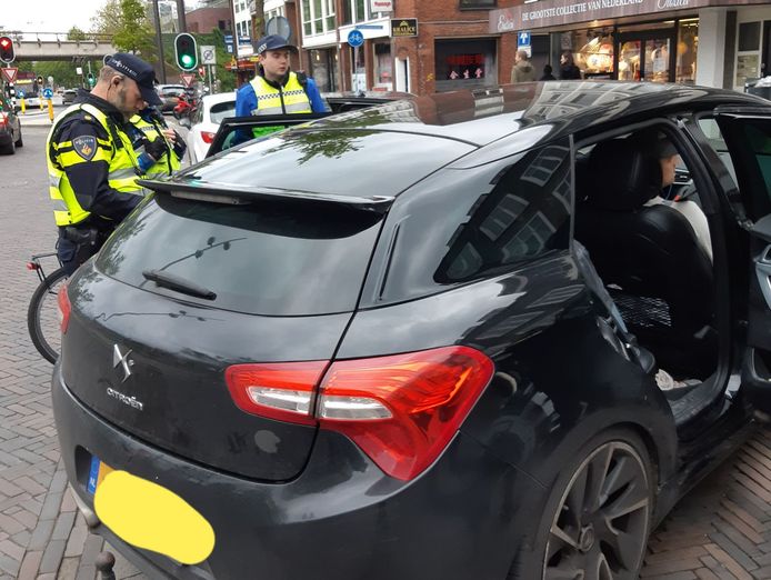 De politie controleert een auto tijdens de 'hyena-actie' in het Spijkerkwartier.