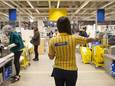 Een werknemer van Ikea wijst verschillende zelfscankassa's toe aan klanten