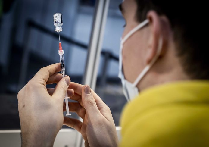 Il personale prepara il vaccino Pfizer presso il sito di vaccinazione dell'aeroporto di Schiphol.