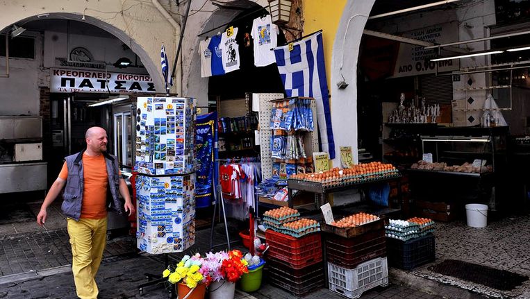 Een man loopt langs een kraampje in Thessaloniki in Griekenland. Beeld anp