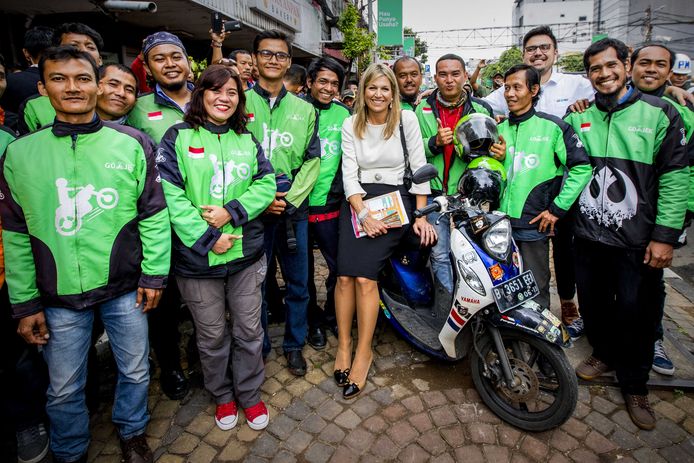 Koningin Maxima tijdens een bezoek aan Indonesië poseert met medewerkers van Go-Jek, een telefonische scooterdienst die verschillende diensten aanbied zoals maaltijden, transport en andere logistieke diensten. Foto Patrick van Katwijk