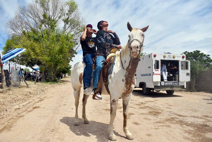 Mannen kijken, gezeten op een paard, naar de zonsverduistering in Nazas, in de staat Durango in Mexico.