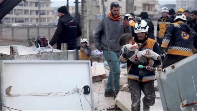 Een reddingswerker met een gered klein meisje in het Syrische Azaz.