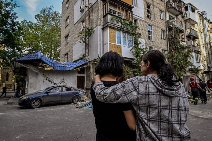 Vrouwen voor een beschadigd woongebouw na beschietingen in de stad Mykolaiv.