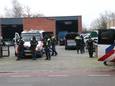 Leden van de Mobiele Eenheid bewaken het autobedrijf Van Harten in Apeldoorn, waar de politie een inval doet.