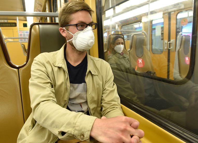 Iemand draagt een mondmasker in de tram in België.  Beeld Photo News