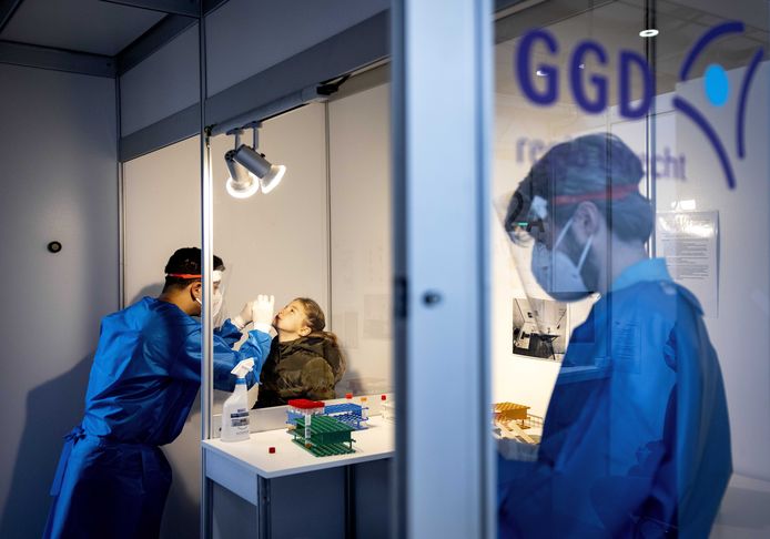 Een GGD-medewerker voert een coronatest uit bij een kind op de XL-vaccinatie locatie van de GGD in de Utrechtse Jaarbeurs.