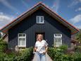Jolanda de Wit voor haar houten huis in de geest van haar ome Niek.