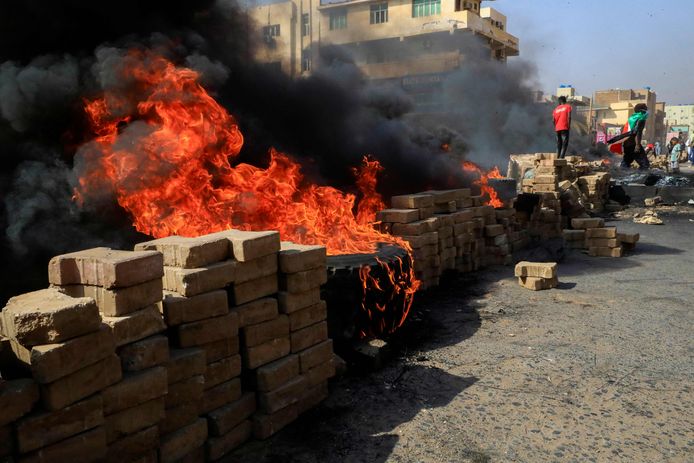 Des manifestants soudanais brûlent des pneus pour bloquer une route dans la 60e rue de la capitale Khartoum, pour dénoncer les détentions nocturnes par l'armée de membres du gouvernement soudanais, le 25 octobre 2021.