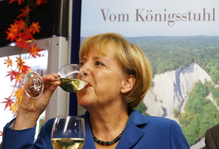 Angela Merkel drinkt een glas wijn nadat zondagavond de eerst uitslagen van exitpolls zijn binnengekomen. Beeld reuters