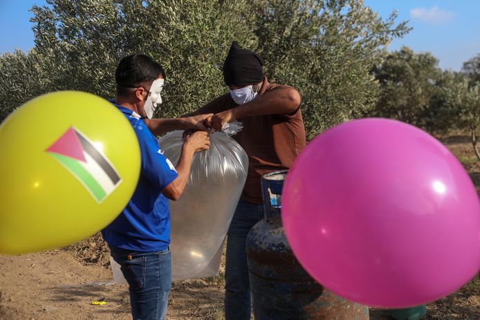 Palestijnen maken brandgevaarlijke ballonnen klaar die ze aan de grens met Israël oplaten.