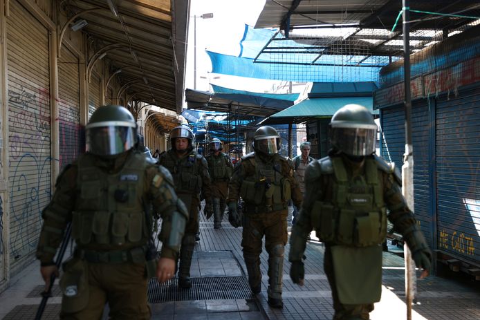 Oproerpolitie patrouilleert een winkelgebied in Santiago, Chili.