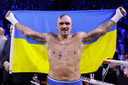 Oleksandr Oesyk viert zijn tweede zege op rij op Anthony Joshua met de vlag van zijn geboorteland Oekraïne.