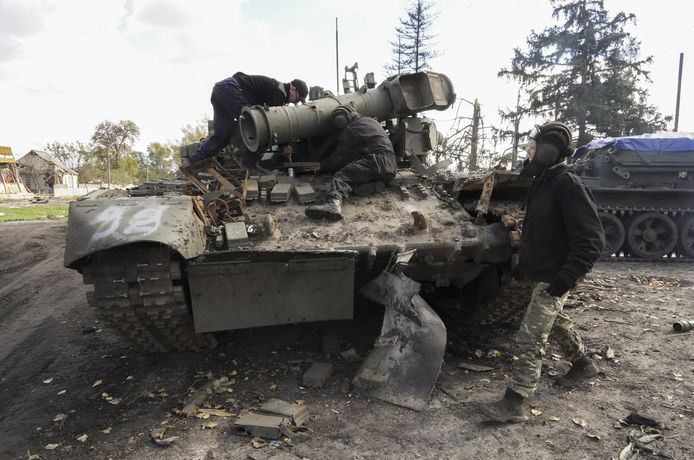 Oekraïense soldaten brengen één en ander in gereedheid om een buitgemaakte Russische tank weg te takelen in Koepjansk. Beeld van 4 oktober.