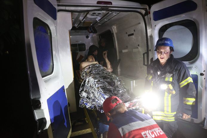 Een gewonde man wordt in een ambulance gelegd.