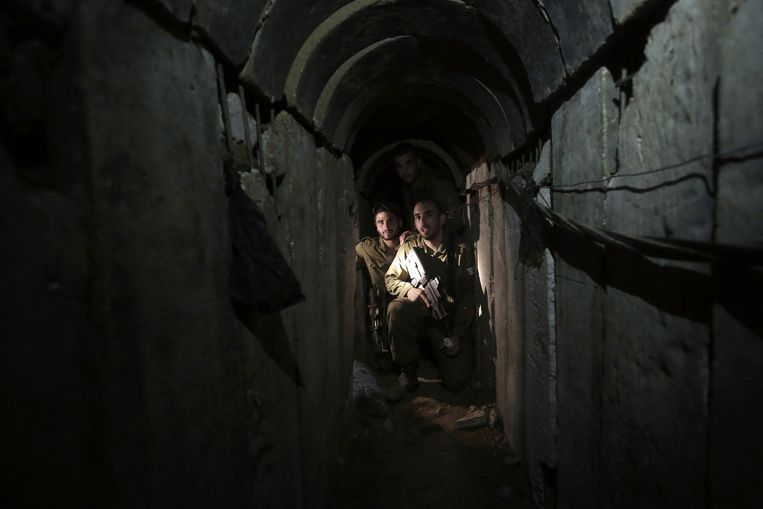 Israëlische soldaten lopen door een tunnel die is ontdekt in het grensgebied. Beeld ap
