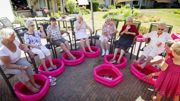 Senioren in voetenbadjes tijdens de hittegolf van twee weken geleden. Beeld anp