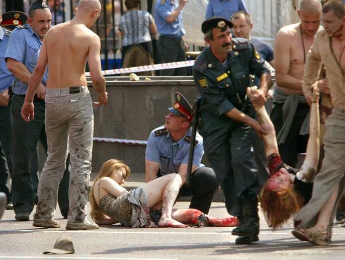 Een politieagent draagt een gewonde festivalganger weg na de aanslag op 5 juli 2003.