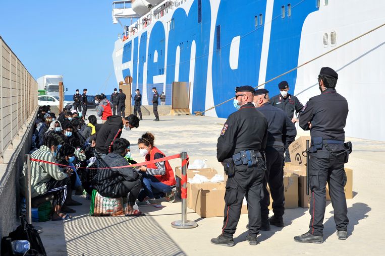 Onder toezicht van Italiaanse politieagenten wachten minderjarige migranten donderdag op vertrek van de veerboot van Lampedusa.  Beeld /Salvatore Cavalli / AP