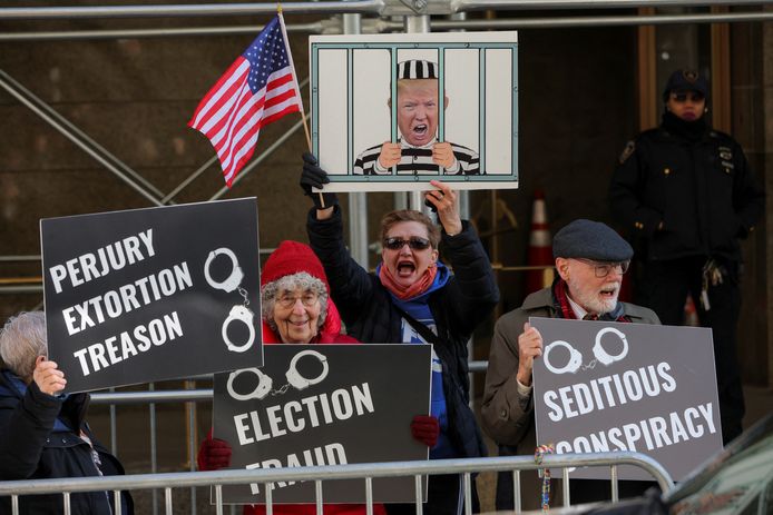 Deze Amerikanen bij de rechtbank in New York protesteren juist tegen ex-president Donald Trump en vinden dat hij in de gevangenis hoort.