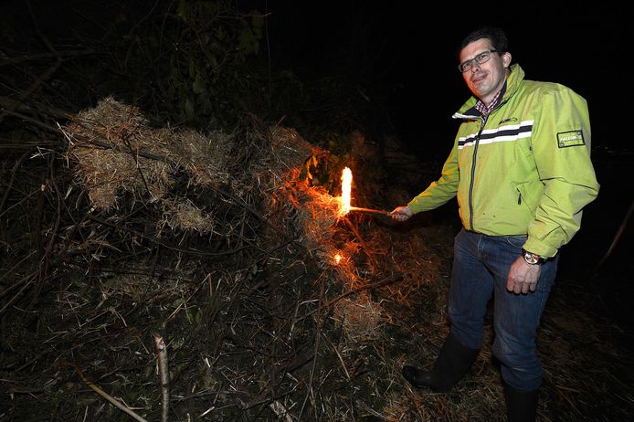Burgemeester Joost van Oostrum steekt de fik in het paasvuur van Lochuizen.