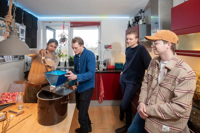 Bierbrouwen in een studentenhuis: samen met een collegastudent is Philip van de Koolwijk (tweede van links) graan aan het schroten (vermalen). Voor optimale efficiëntie heeft hij een boor aangesloten op de graanmolen.