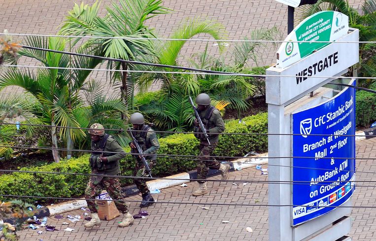 Keniaanse militairen proberen het winkelcentrum Westgate binnen te dringen, waar militanten van al-Shabaab zich in september vorig jaar schuil hielden. Beeld REUTERS