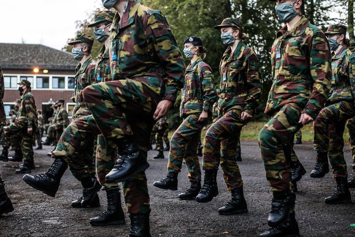 In camouflagepak en met mondmasker aan, tijdens de dril.