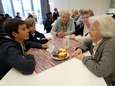 Senioren en scholieren samen aan tafel voor speeddates