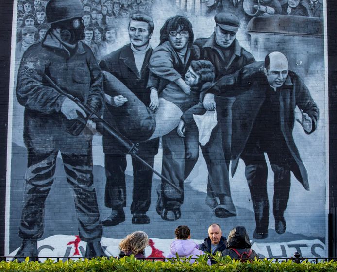 Mensen zaterdag aan een muurschildering over Bloody Sunday in Bogside, Derry.
